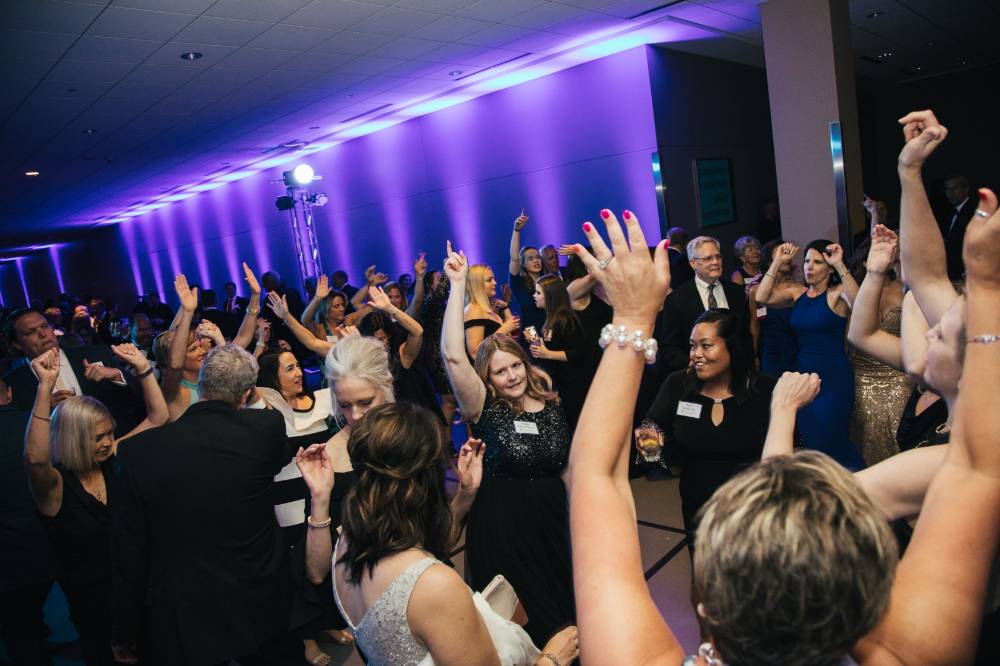 Guests dancing, throwing their hands in the air in the Laker Lounge.